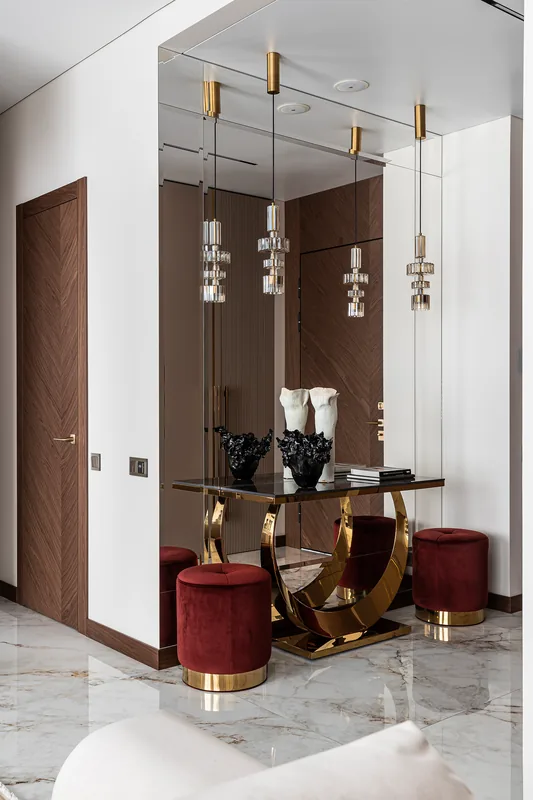 Entryway: console table and poufs against mirrored panels