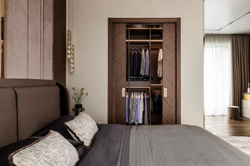 Walk-in wardrobe behind hinged doors: rails and shelves for the owners' belongings