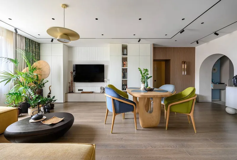 Living room: TV area with white fluted fronts and tall cabinets, dining table
