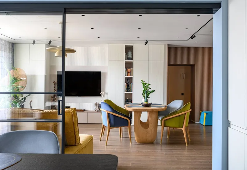 View of the living room from the kitchen: TV area, floor-to-ceiling cabinets and dining set