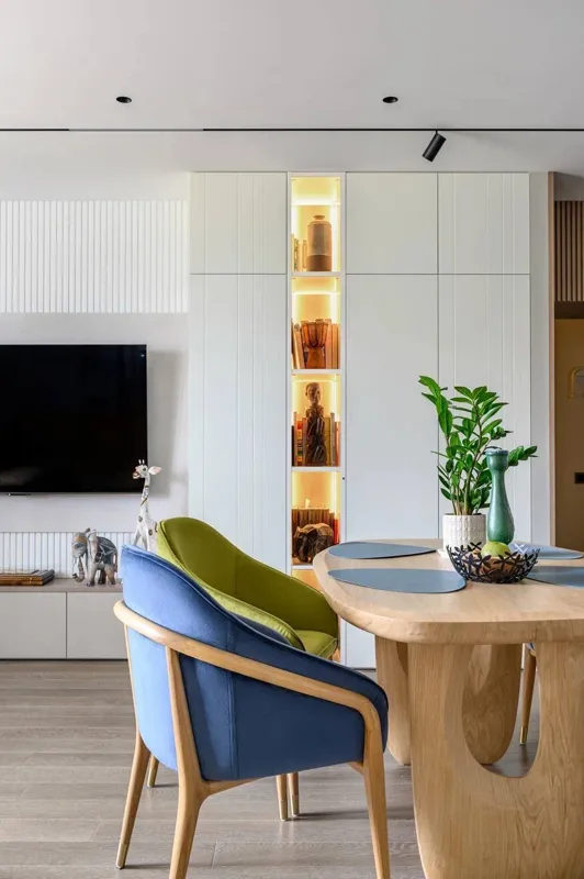 Tall cabinet with illuminated open shelves next to the TV area